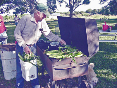 Malcolm putting sweet corn on the grill for roasting in '02